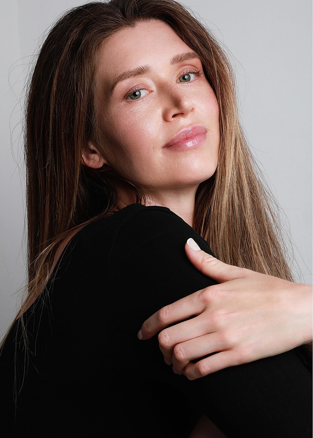 Smiling woman with long hair, black top.